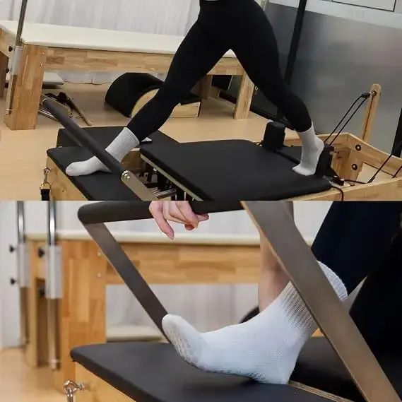 Woman wearing white grip socks on a Pilates reformer